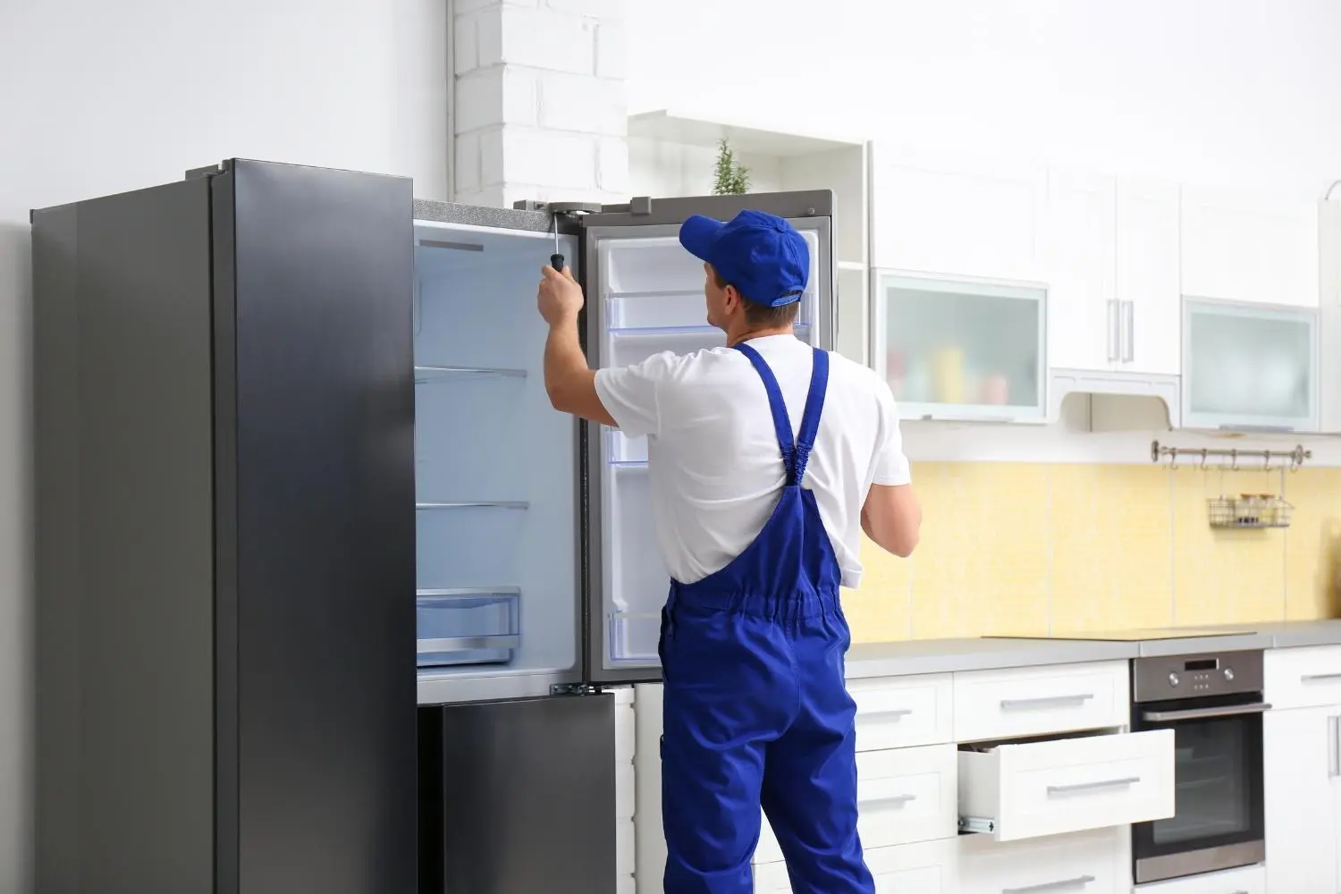 repairmain-is-repairing-a-refrigerator-in-a-household