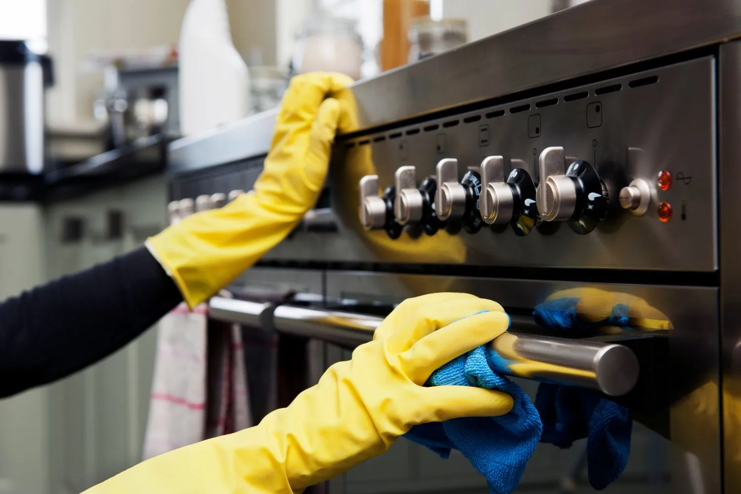a-person-is-wearing-safety-gloves-while-cleaning-gas-oven